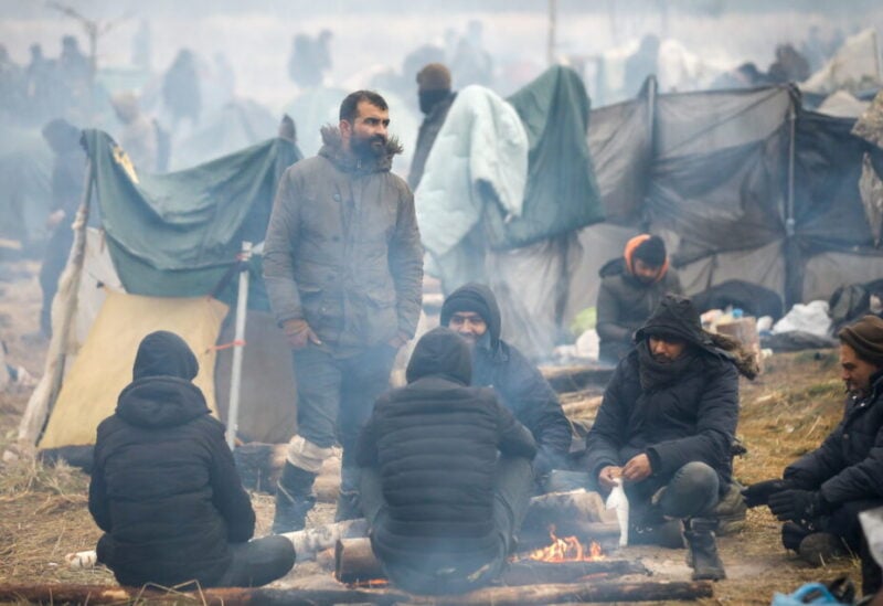 Migrants gather around a fire in a camp near Bruzgi-Kuznica checkpoint on the Belarusian-Polish border in the Grodno region, Belarus, November 18, 2021. REUTERS/Kacper Pempel