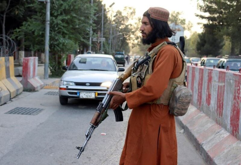 A Taliban fighter stands guard at a check point in Kabul,