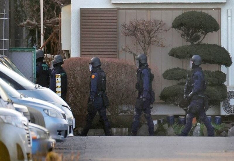 Police officers deploy around a private house where a man holds a hostage in Fujimino, Saitama prefecture