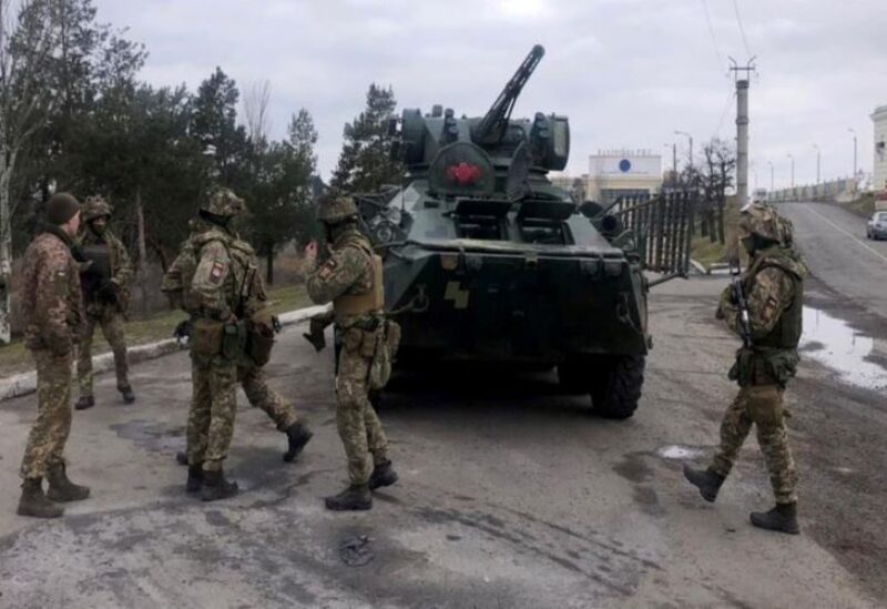 Ukraine's servicemen standing past a tank during a large-scale anti-terrorism exercises in Kherson