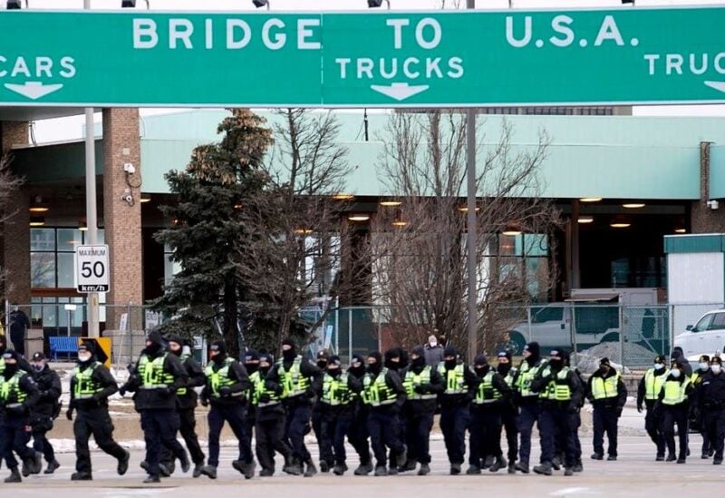 Canadian police deploy on February 12, 2022, to move protesters blocking access to the Ambassador Bridge demanding an end to government COVID-19 mandates, in Windsor, Ontario, Canada.