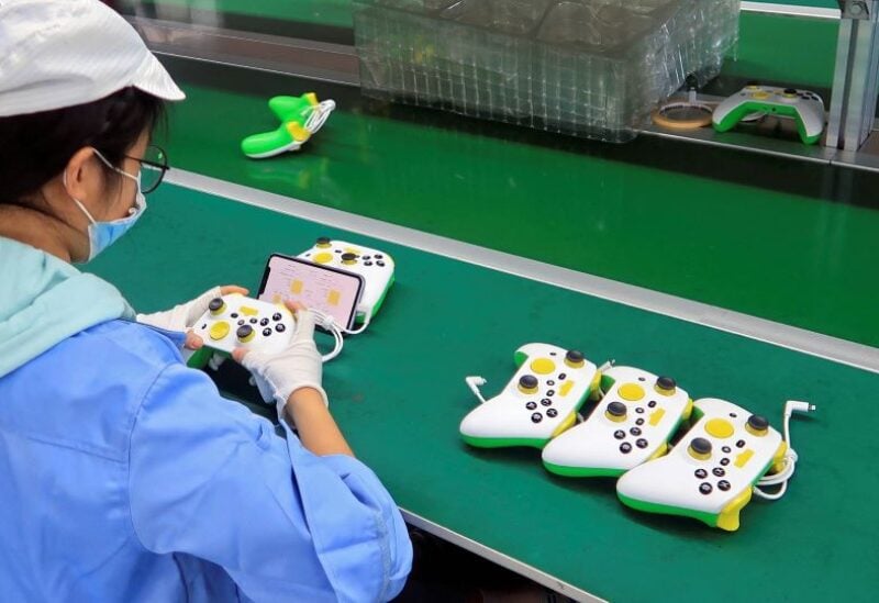 Employees work on the production line of RiotPWR mobile gaming controllers for U.S. company T2M,