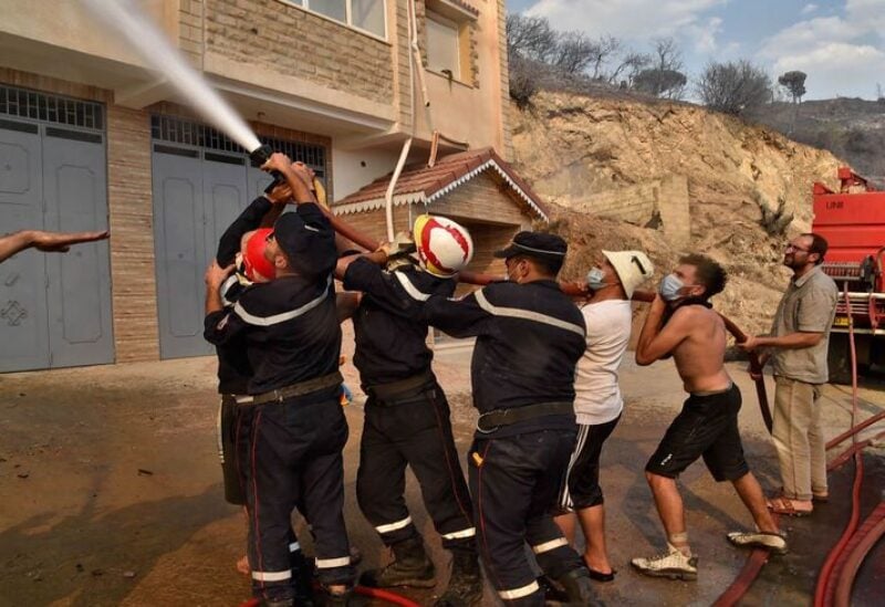 Firefighters battle the flames of a building on fire, in Algeria