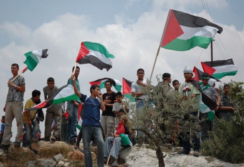 Palestinian protesters wave a national flag during a demonstration