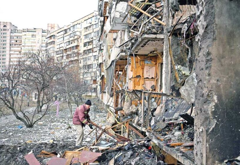 People gather in front of a damaged residential building at Koshytsa Street, a suburb of the Ukrainian capital Kyiv, where a military shell allegedly hit,