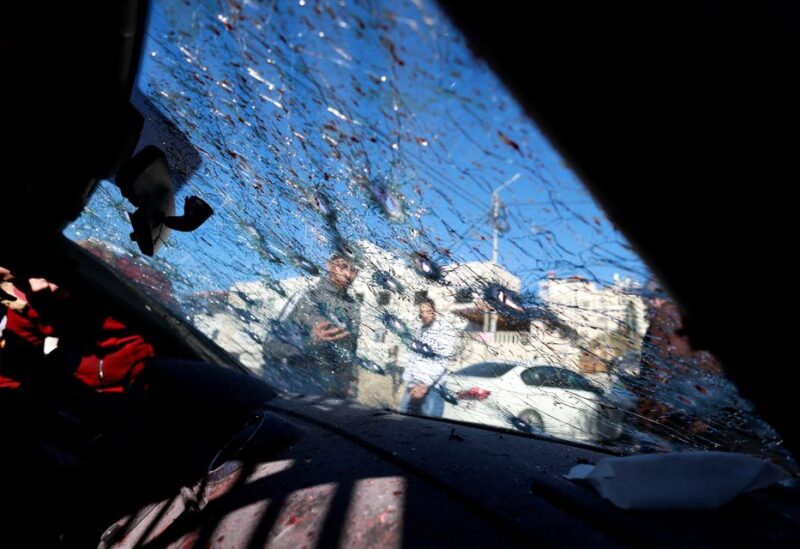 People inspect the scene where three Palestinian gunmen were killed by Israeli forces