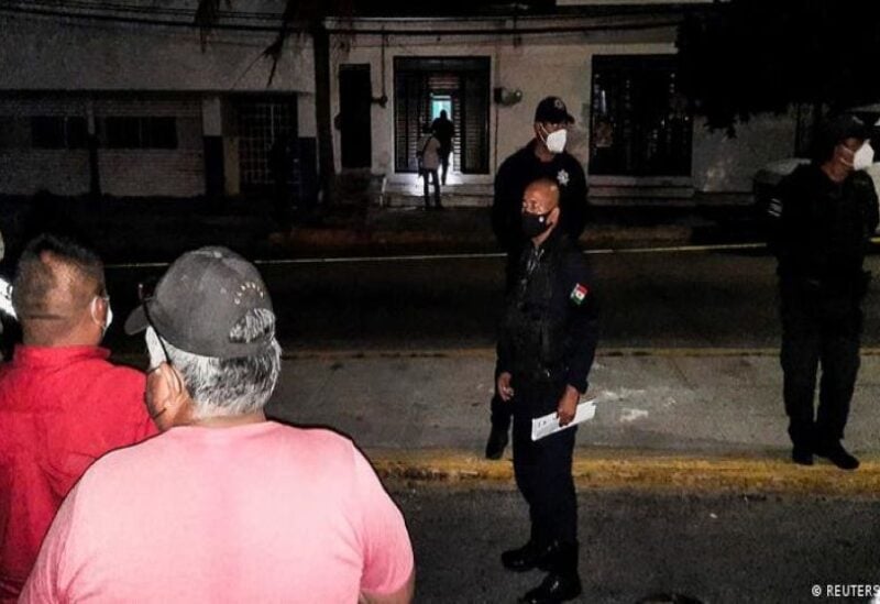 Police officers guard the perimeter of a scene where Heber Lopez, an independent journalist