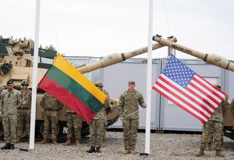 Soldiers hold Lithuanian and U.S. flags