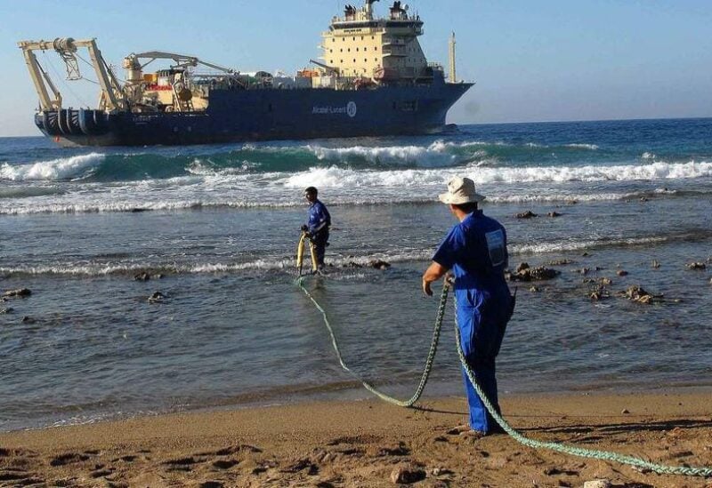 Workers pay out an undersea fibre-optic cable from the coast of Cuba