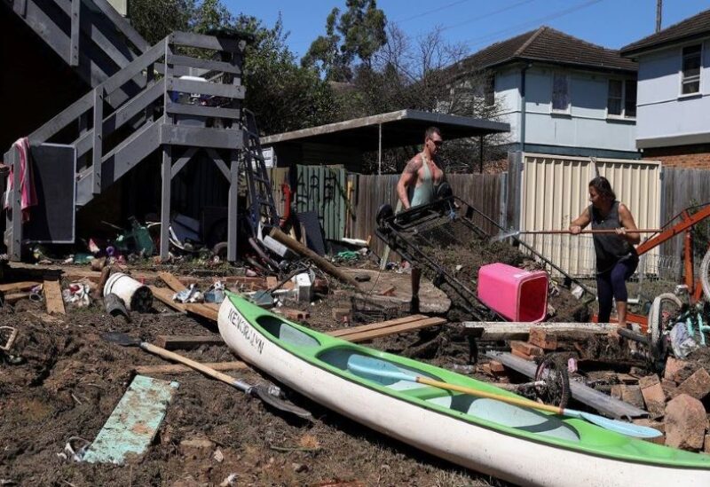 File photo of local residents clean up debris in the aftermath of the area getting inundated with floodwaters following prolonged rains and a severe weather event in the suburb of Windsor in Sydney, Australi
