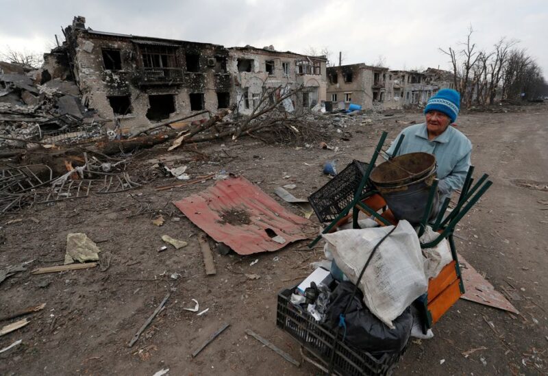 A woman pushes a trolley with her belongings along a street damaged during Ukraine-Russia conflict in the separatist-controlled town of Volnovakha in the Donetsk region, Ukraine.