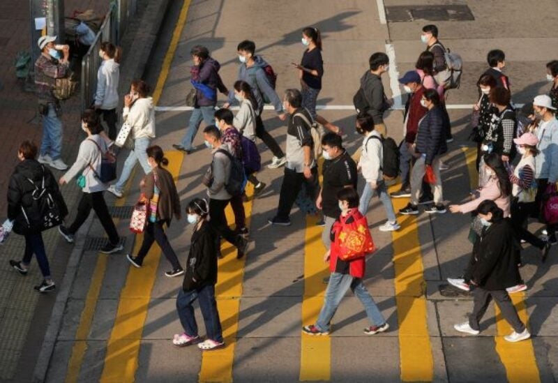 People wearing face masks cross a street following the coronavirus disease (COVID-19) outbreak, in Hong Kong, China February 15, 2022. REUTERS/Lam Yik
