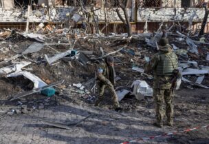 Ukrainian servicemen inspect the area in front of a residential apartment building after it was hit by shelling as Russia's invasion of Ukraine continues, in Kyiv, Ukraine, March 15, 2022.