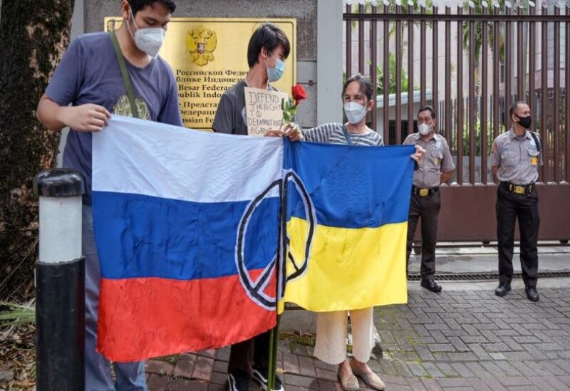 Protesters display the flags of Russia and Ukraine during an anti-war demonstration in front of the Russian embassy in Jakarta