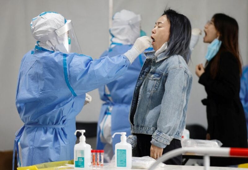 Medical workers in protective suits collect swabs samples from residents at a makeshift nucleic acid testing site amid a mass testing for the coronavirus disease (COVID-19) in Chaoyang district of Beijing, China April 27, 2022. REUTERS/Carlos Garcia Rawlins