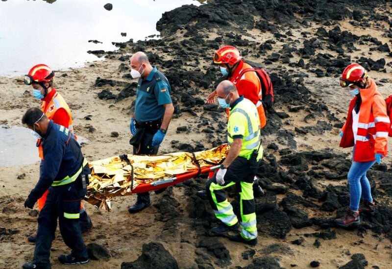 Rescue workers carry the body of a dead person after a boat with 35 migrants from the Maghreb region capsized in the beach of Orzola, in the Canary Island of Lanzarote, Spain, November 25, 2020. REUTERS/Borja Suarez/File Photo