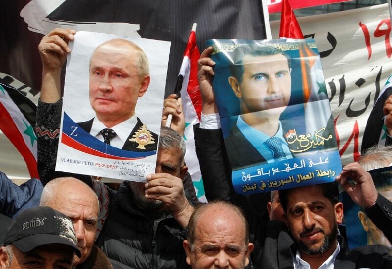 People hold a poster of Russian President Vladimir Putin and Syrian President Bashar al-Assad during a rally in support of Russia's military invasion of Ukraine, in front of the U.N. headquarters in Beirut, Lebanon March 20, 2022. REUTERS/Aziz Taher