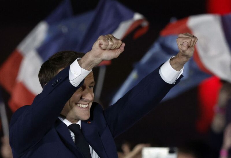 French President Emmanuel Macron gestures on stage, after being re-elected as president - REUTERS