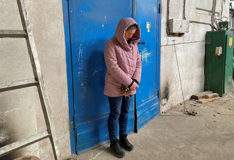 Red Cross volunteer Yulia Ivannikova-Katsemon stands in front of the door to the factory room where she was held for several days after being detained by Russian troops during Russia's invasion of the village of Dymer, in Kyiv region, Ukraine April 14, 2022. Picture taken April 14, 2022. REUTERS/Alessandra Prentice