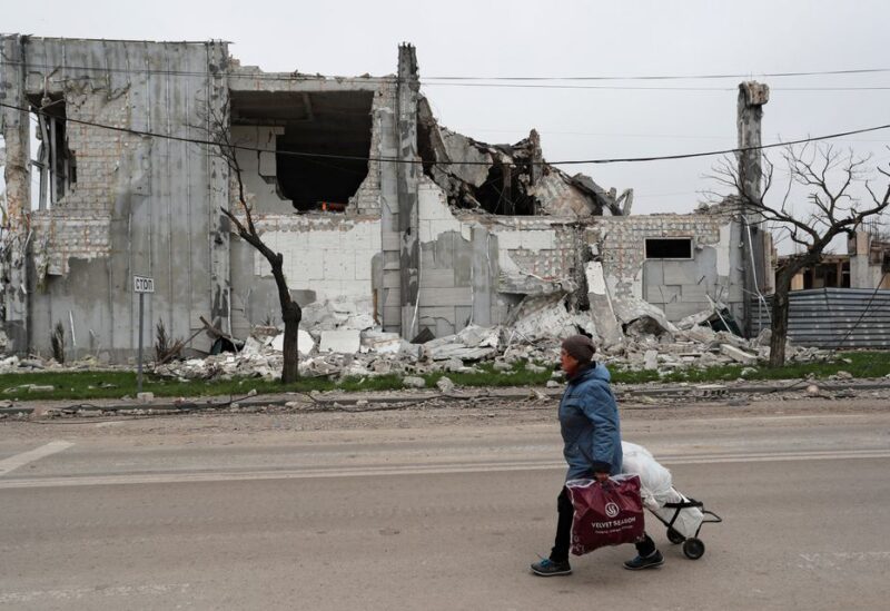A local resident walks past a building destroyed during Ukraine-Russia conflict in the southern port city of Mariupol, Ukraine April 19, 2022. REUTERS/Alexander Ermochenko