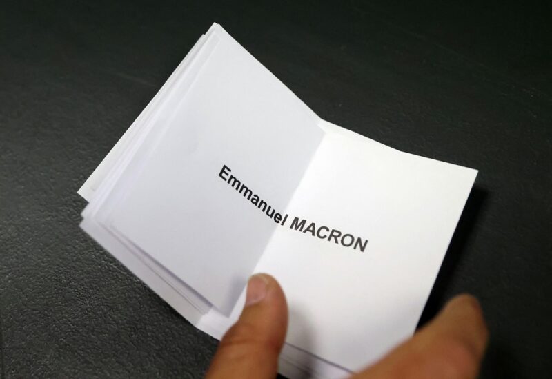 An official stacks ballots for French President Emmanuel Macron, candidate for his re-election, during counting the votes from the second round of the 2022 French presidential election at a polling station in Henin-Beaumont, France, April 24, 2022. REUTERS/Johanna Geron