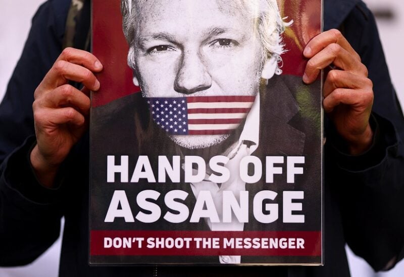 A supporter of Julian Assange displays a placard, outside the Westminster Magistrates' Court in London, Britain April 20, 2022. REUTERS/Tom Nicholson