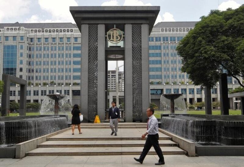 People walk near an entrance to Bank Indonesia's headquarters in Jakarta, Indonesia January 14, 2016. Indonesia's central bank, comfortable that higher U.S. interest rates have not spurred big outflows, cut its interest rates for the first time in nearly a year to try to lift an economy growing at its slowest pace since the global financial crisis. REUTERS/Garry Lotulung