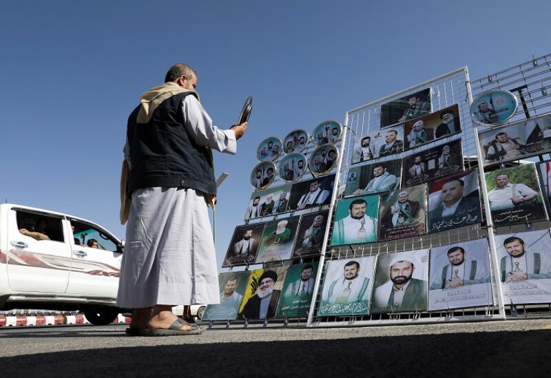 A man looks at a souvenir next to a stall selling posters and souvenirs with images of Houthi leaders in Sanaa, Yemen April 7, 2022. REUTERS/Khaled Abdullah