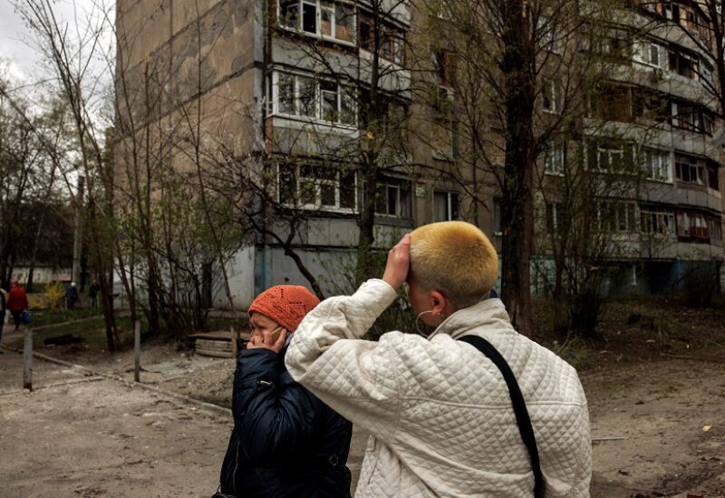 A woman reacts as another speaks on the phone, following Russian shelling amid Russia's attack on Ukraine, in Kharkiv, Ukraine, April 19, 2022. REUTERS/Alkis Konstantinidis