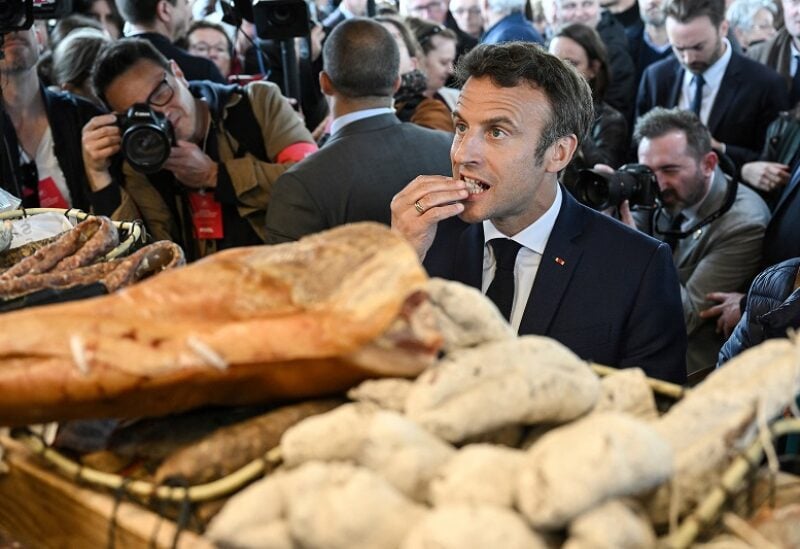 French President Emmanuel Macron eats some food, during a visit to Barbazan-Debat, Hautes-Pyrenees, France, April 29, 2022. Caroline Blumberg/Pool via REUTERS
