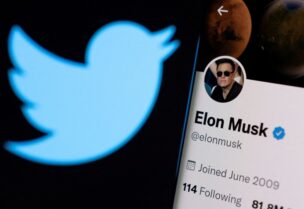 FILE PHOTO: Elon Musk's twitter account is seen on a smartphone in front of the Twitter logo in this photo illustration taken, April 15, 2022