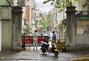 FILE PHOTO: A courier in a protective suit makes deliveries to a residential compound amid the coronavirus disease (COVID-19) outbreak in Shanghai, China, April 23, 2022. REUTERS/Brenda Goh/File Photo