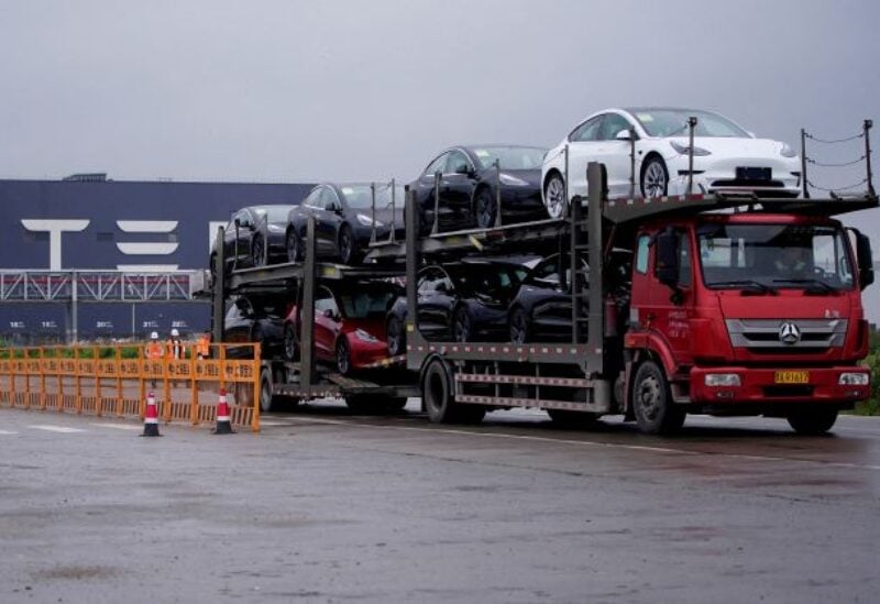 A truck transports new Tesla cars at its factory in Shanghai - REUTERS