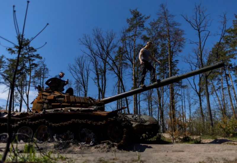 Local residents climb on top of a destroyed Russian tank, as Russia's attack on Ukraine continues, near Irpin, Ukraine May 6, 2022. REUTERS/Carlos Barria TPX IMAGES OF THE DAY