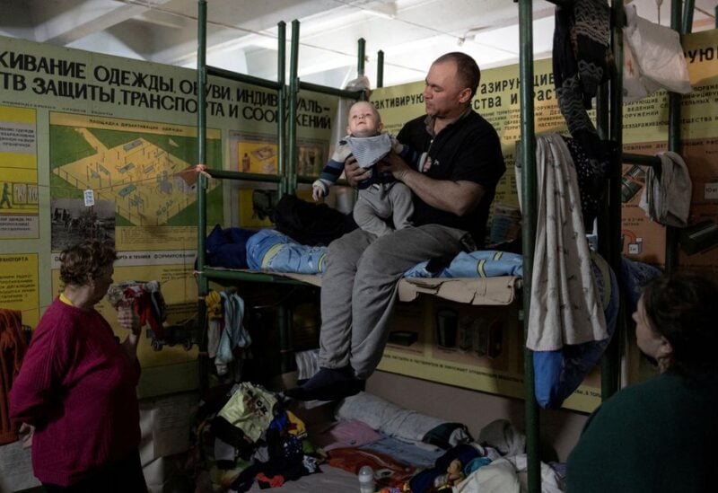 A man holds his baby inside Azot chemical plant's bomb shelter, where people have been hiding from from shelling since the beginning of the war, in Sievierodonetsk, Luhansk region, Ukraine, April 16, 2022. REUTERS/Marko Djurica