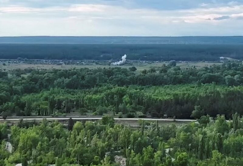 Smoke rises in the distance after an explosion of a building in this still image taken from a video released by Ukrainian military, which according to them shows Russian army position set up near a private house being attacked, amid Russia's invasion of Ukraine, in Vojevodivka, Luhansk region, Ukraine, released May 26, 2022. Special Operations Forces Command/Handout via REUTERS