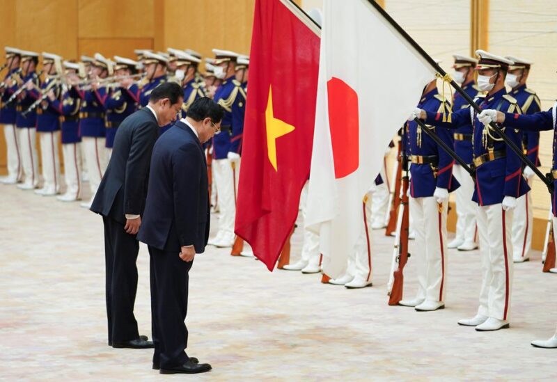Vietnam's Prime Minister Pham Minh Chinh and Japan's Prime Minister Fumio Kishida bow in front of their national flags as they review a guard of honour ahead of a meeting at the prime minister's official residence in Tokyo, Japan, November 24, 2021. Toru Hanai/Pool via REUTERS