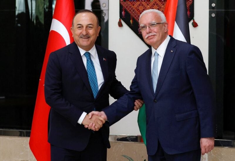 Palestinian Foreign Minister Riyad al-Maliki shakes hands with Turkish Foreign Minister Mevlut Cavusoglu, in Ramallah, in the Israeli-occupied West Bank May 24, 2022. REUTERS/Mohamad Torokman
