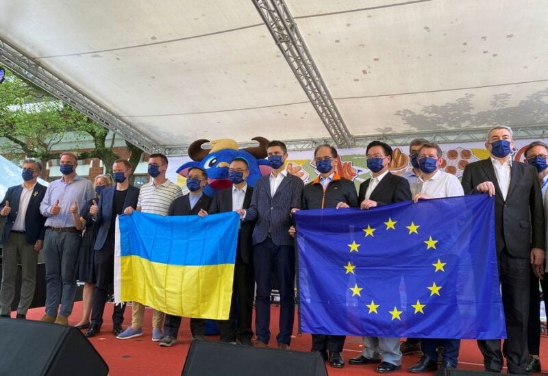Head of European Economic and Trade Office (EETO) Filip Grzegorzewski, holds EU and Ukrainian flags next to Taiwan Parliament speaker You Si-kun, Foreign Minister Joseph Wu and other European diplomats at an Europe Day event in Taipei, Taiwan May 7, 2022. REUTERS/Ben Blanchard