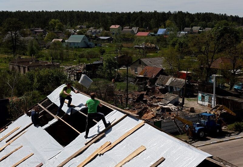 Men rebuild a roof, amid Russia's invasion of Ukraine, in Moshchun village, Kyiv region, Ukraine May 19, 2022. REUTERS/Edgar Su TPX IMAGES OF THE DAY