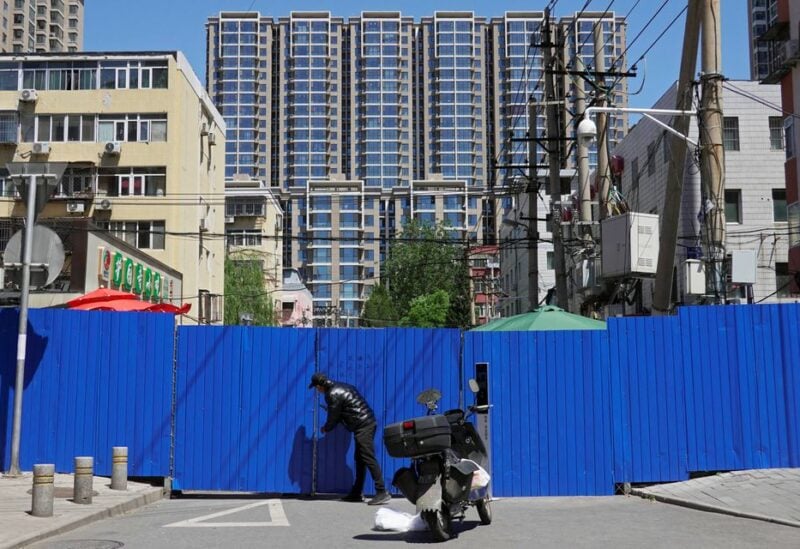 A man makes deliveries to a barricaded residential area under lockdown amid the coronavirus disease (COVID-19) outbreak in Beijing, China May 13, 2022. REUTERS/Thomas Suen