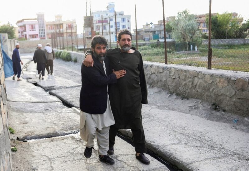FILE PHOTO: Afghan men flee near the site of explosions at Khalifa Sahib Mosque in Kabul, Afghanistan April 29, 2022. REUTERS/Ali Khara/File Photo