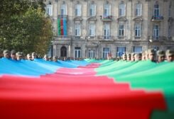 FILE PHOTO: Azeri service members carry a giant flag during a procession marking the anniversary of the end of the 2020 military conflict over Nagorno-Karabakh breakaway region, involving Azerbaijan's troops against ethnic Armenian forces, in Baku, Azerbaijan, November 8, 2021. REUTERS/Aziz Karimov/File Photo