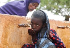 Somali displaced girl Sadia Ali, 8, drinks water from a tap at the Kaxareey camp for the internally displaced people in Dollow, Gedo region of Somalia May 24, 2022. Picture taken May 24, 2022. REUTERS/Feisal Omar