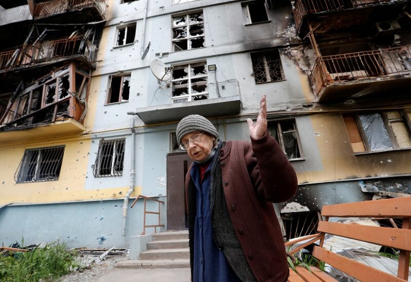Local resident and music teacher Natalya Lebed, 74, speaks in front of a block of flats damaged during Ukraine-Russia conflict in the southern port city of Mariupol, Ukraine May 11, 2022. REUTERS/Alexander Ermochenko