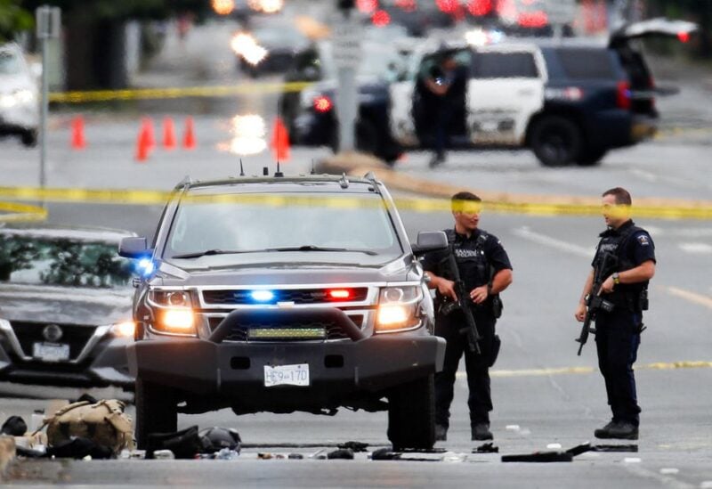 Police officers gather after two armed men entering a bank were killed in a shootout with police in Saanich, British Columbia, Canada June 28, 2022. REUTERS/Kevin Light