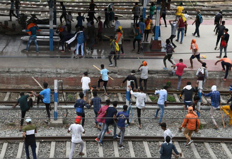 Protestors carrying sticks run at a railway station during a protest against "Agnipath scheme" for recruiting personnel for armed forces, in Patna, in the eastern state of Bihar, India, June 17, 2022. REUTERS/Stringer