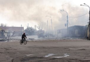 A man rides on a bicycle in front of a building after it was hit by shelling in Lysychansk, Luhansk region, Ukraine, April 16, 2022. REUTERS/Marko Djurica