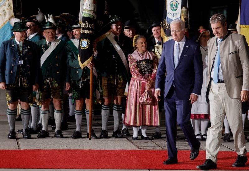 U.S. President Joe Biden walks with Bavaria's State Premier Markus Soeder past people in traditional Bavarian clothes as Biden arrives for a G7 summit aboard Air Force One at Munich International Airport near Munich, Germany June 25, 2022. REUTERS/Jonathan Ernst