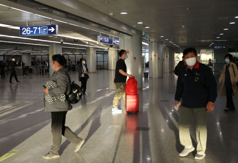 Travellers walk at the Beijing Capital International Airport in Beijing, China May 9, 2021. REUTERS/Tingshu Wang